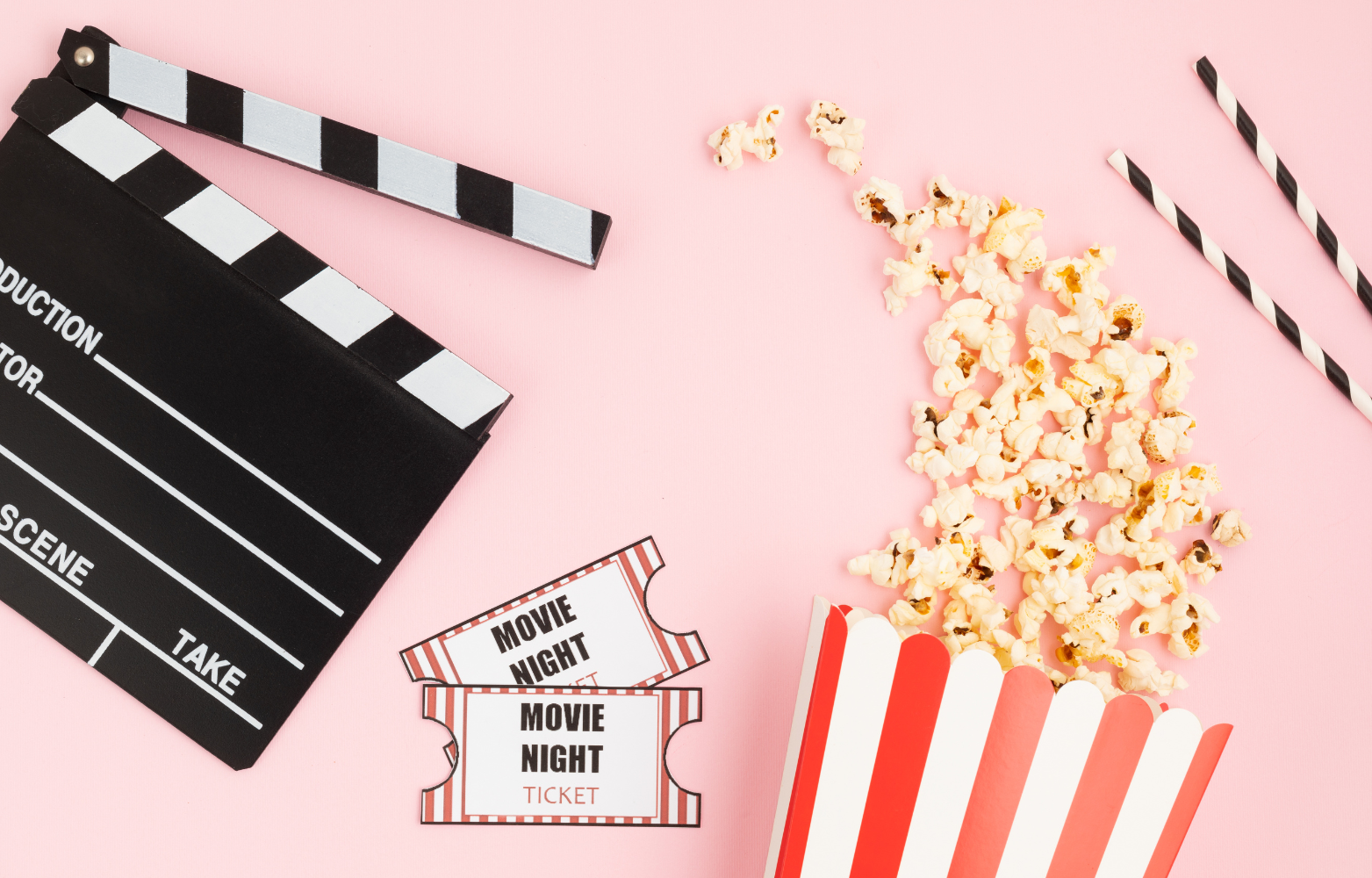 popcorn movie tickets straws and directors cut board on pink background